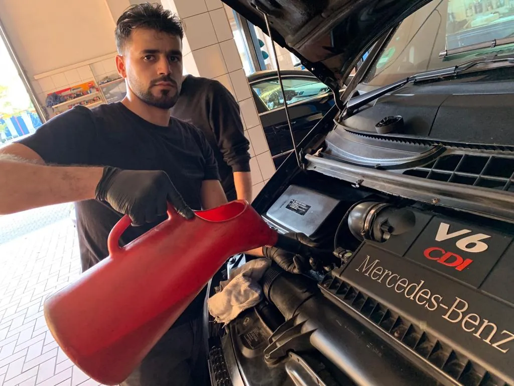 Öl wird am geöffneten Motor nachgefüllt
